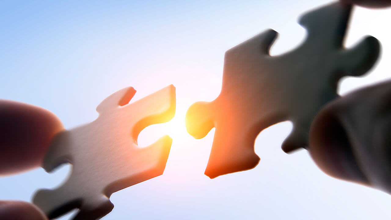 Close up of two puzzle pieces joining together Close up of two puzzle pieces joining together